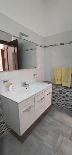 La salle de bains est pourvue d'un lavabo et d'un miroir. dans l'établissement Appartamento Monte Argentu, à Fluminimaggiore