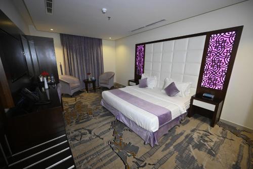a hotel room with a bed and a large window at Aster Hotel in Jeddah