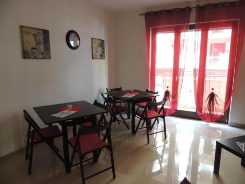 a dining room with tables and chairs and a window at Domus Taranto unica sede in Taranto