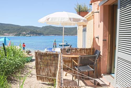 stół z parasolem na plaży w obiekcie Oyster Beach - Direttamente sulla Spiaggia del Forno w mieście Scaglieri