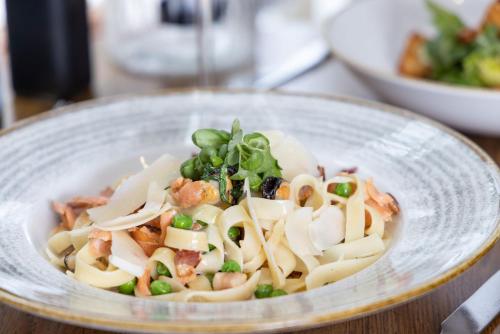 a bowl of pasta with shrimp and peas on a table at The Ship in Parkgate