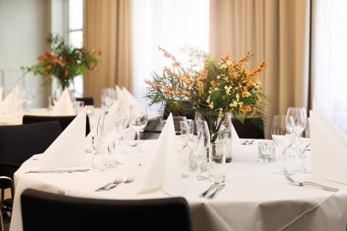 a table with glasses and vases with flowers on it at Elite Palace Hotel & Spa in Stockholm