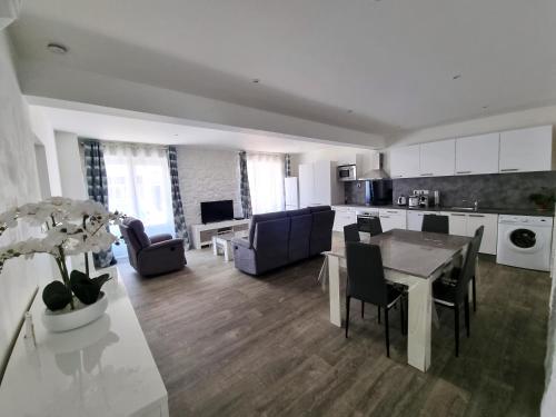 une cuisine et un salon avec une table et des chaises dans l'établissement Bel appartement 2 chambres climatisé centre ville, à Nice