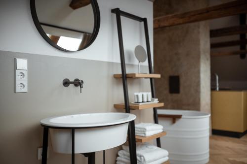 a bathroom with a sink and a mirror and a tub at Castel Maurn in San Lorenzo di Sebato