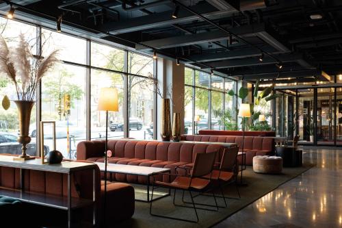 a lobby with couches and tables and windows at Elite Palace Hotel & Spa in Stockholm