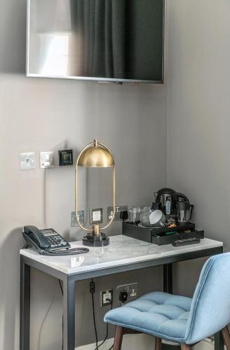 a desk with a mirror and a blue chair at The Scott in Edinburgh
