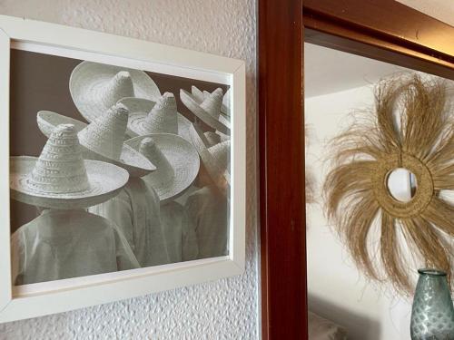 a picture of hats in a picture frame on a wall at Precioso apartamento en el puerto de Elantxobe in Elanchove