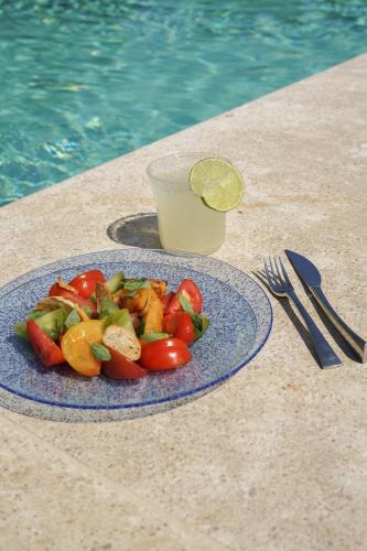 a plate of vegetables on a table with a glass of juice at Hostellerie De Levernois in Levernois