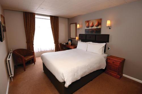 een hotelkamer met een groot bed en een raam bij White Hart, Exeter by Marston's Inns in Exeter