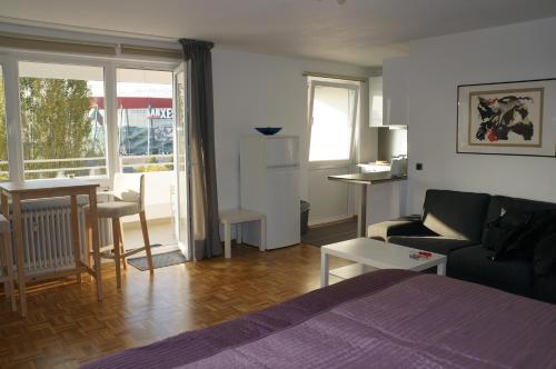 a room with a bed and a couch and a table at Köln Deutz/Messe, Lanxess Arena in Cologne