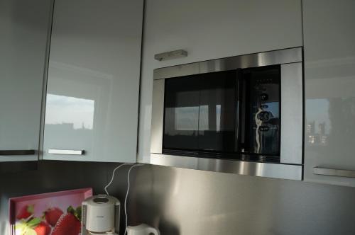 a microwave in a kitchen with a picture of strawberries at Köln Deutz/Messe, Lanxess Arena in Cologne