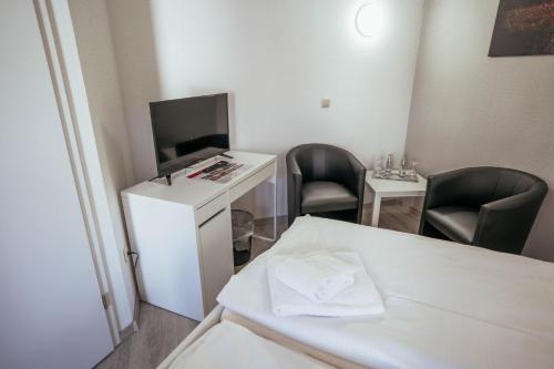 a small room with two chairs and a table with a television at REGIOHOTEL Wolmirstedter Hof Wolmirstedt in Wolmirstedt