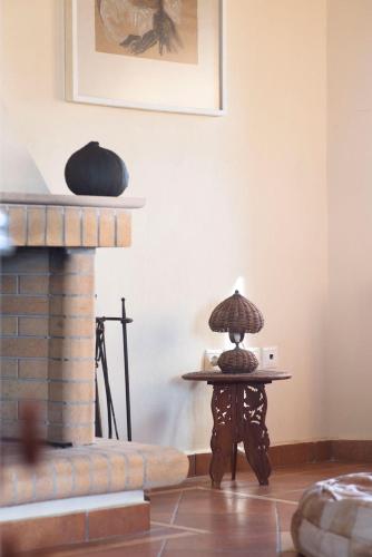 a table with a lamp on it next to a fireplace at Daphne in Ermioni