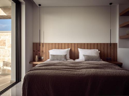 a bedroom with a large bed with two pillows at Anthis Luxury Villas - A Haven of Serene Modern Elegance, by ZanteWize in Zakynthos Town