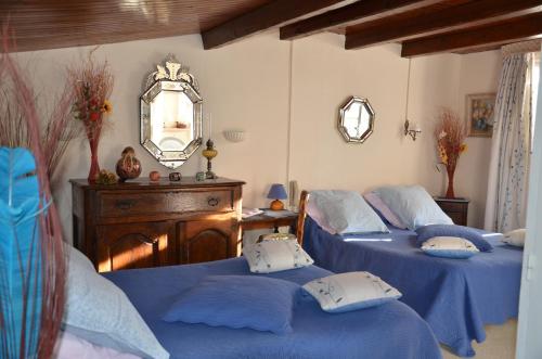 a bedroom with two beds and a mirror at Auberge du Lac in Bauduen
