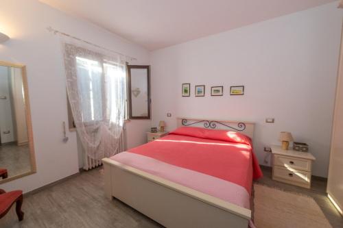 a bedroom with a red bed and a mirror at Casacobelli in Monzambano