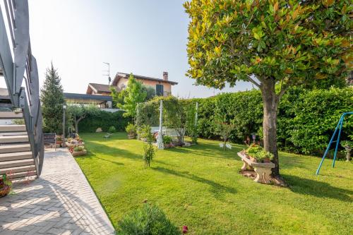 a garden with a tree and a swing at Casacobelli in Monzambano