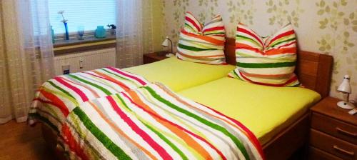 uma cama com um cobertor colorido em cima em Ferienwohnung Sille em Osnabrück