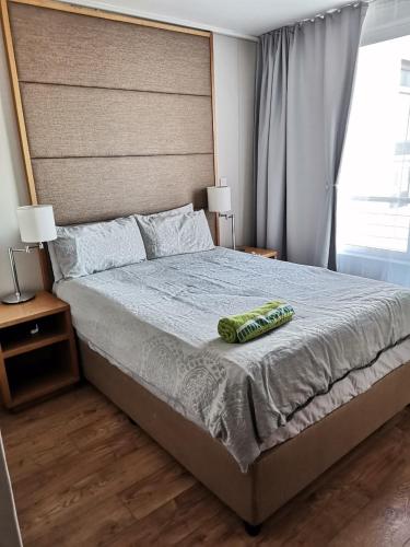 a bedroom with a large bed with two pillows on it at Lagoon Beach Apartment 309 in Cape Town