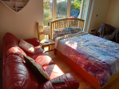 a bedroom with a bed and a couch and a window at No 9 Manor Way in Carmarthen