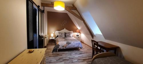 a bedroom with a bed and a table in a room at La Ferme aux Fleurs in Ossun