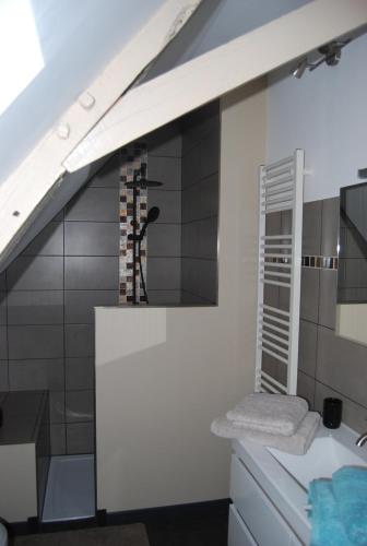 uma casa de banho com um balcão branco e um lavatório em La Ferme aux Fleurs em Ossun