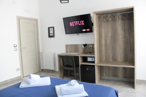 a room with a tv and a bed with towels at B&B D'Amari Affittacamere in Palermo