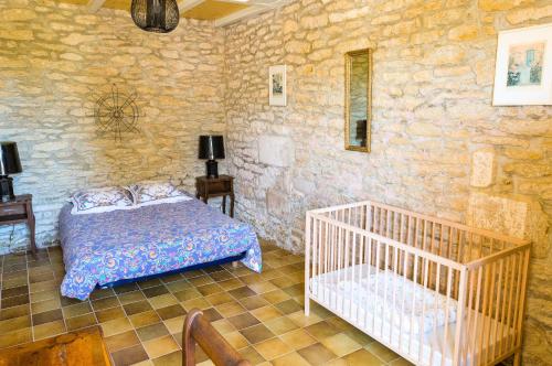 une chambre avec un lit et un mur en pierre dans l'établissement Vacances entre mer et campagne pour 8, à Plobannalec-Lesconil