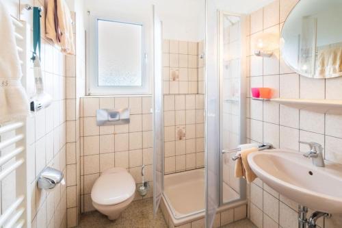a bathroom with a toilet and a sink and a shower at Dünenblick - a65692 in Baltrum
