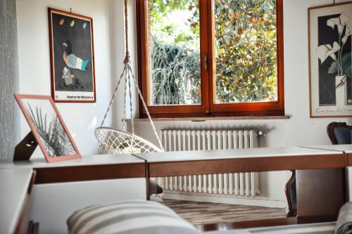 a living room with two windows and a chair at Villa Sequoia in Leinì