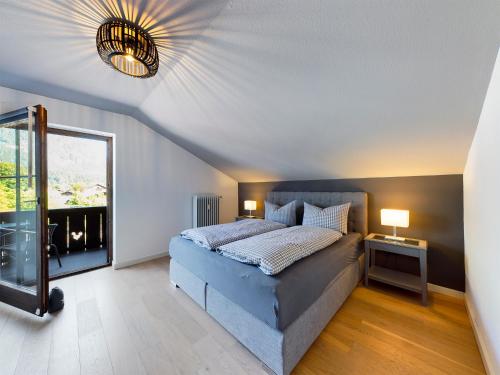 een slaapkamer met een bed en een groot raam bij Hausberg No. 2 // NEU in Garmisch-Partenkirchen