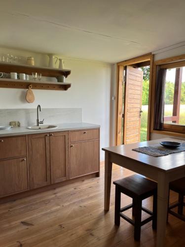 a kitchen with a table and a sink and a counter at Lūķi, Lauku sēta in Jūrkalne