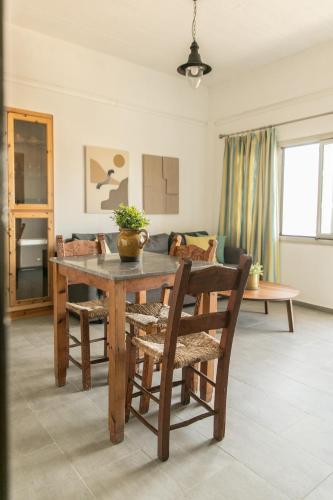 a dining room with a wooden table and chairs at Creta Vitalis in Kalathas