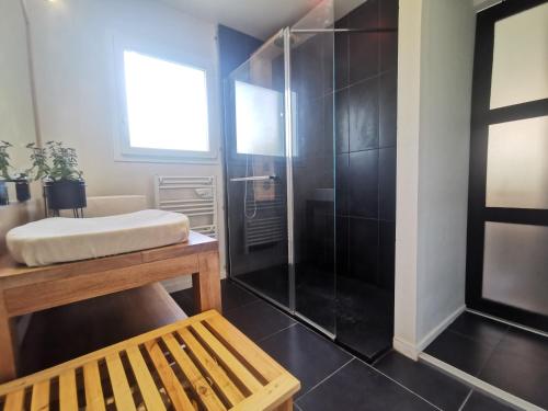 La salle de bains est pourvue d'une douche en verre et d'un banc. dans l'établissement Villa Milea - Lège Cap-Ferret, à Lège-Cap-Ferret