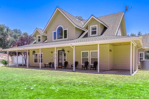a house with a large front porch with chairs at Wooded Bliss in Mariposa