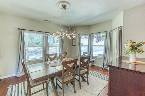 a dining room with a table and chairs and windows at Wooded Bliss in Mariposa