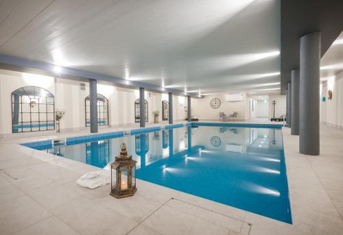ダグラスにあるComis Hotel & Golf Resortの青いプール付きの建物内の大型スイミングプール