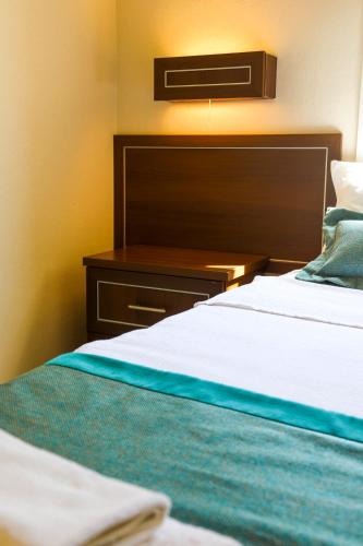 a hotel room with two beds and a night stand at The Aegean Gate Hotel in Bodrum City
