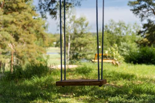 a swing in a park with a field of grass at Villa Ekbladh in Västanfjärd