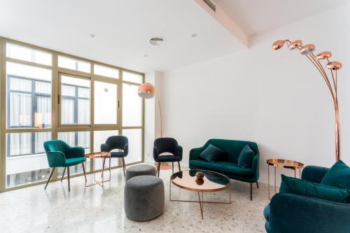 sala de estar con sillas verdes y mesa en Veoapartment Casa Pedro, en Sevilla