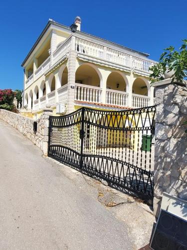 ein großes weißes Haus mit einem schwarzen Tor in der Unterkunft Apartment Kamenar in Primošten
