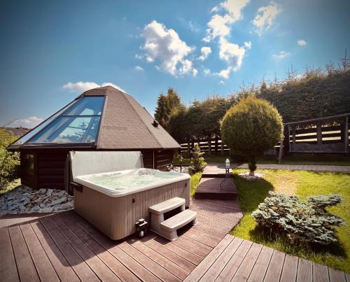 a hot tub on a deck with a gazebo at Osada Koniaków 4 in Koniaków