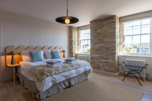 a bedroom with a large bed and a brick wall at Finest Retreats - ARC Padstow in Little Petherick