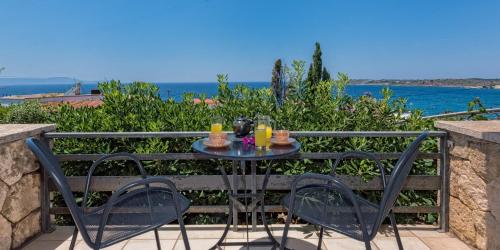a table with two chairs and drinks on a balcony at Creta Vitalis in Kalathas