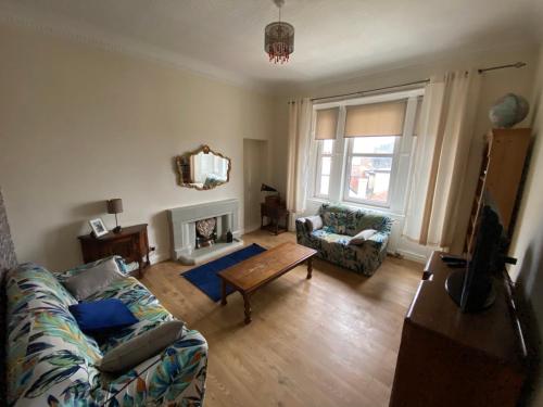 a living room with a couch and a table at Dalblair Apartment in Ayr