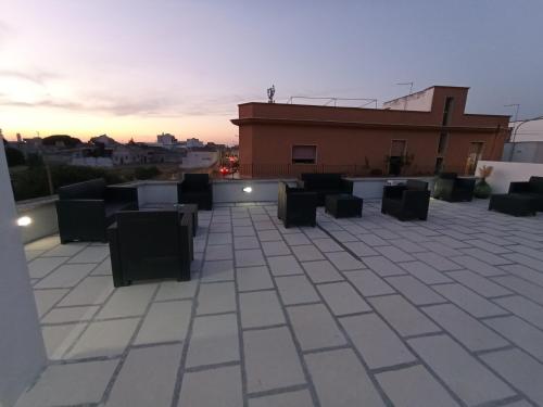 a rooftop with tables and chairs on a building at B&B Lo Scrigno del Salento in Sava