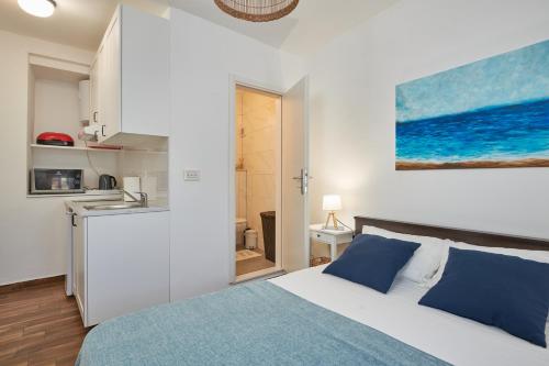 1 dormitorio blanco con 1 cama y cocina en Studio apartment Tramonto, en Cavtat