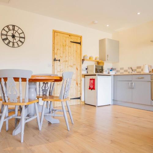 a kitchen and dining room with a table and chairs at Muntjac View, Beechcroft Barns, Cawston, Norfolk in Norwich