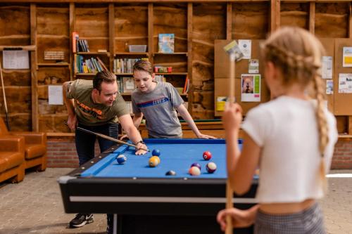 a man and a woman playing a game of pool at Charmecamping & Appartementen De Regge-Vallei in Den Ham