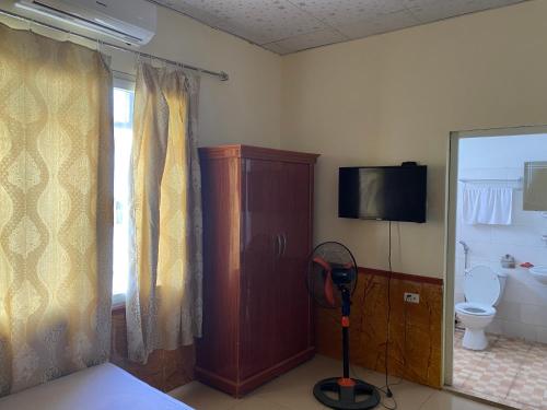 um quarto com casa de banho com WC e televisão em Nhà nghỉ FAMY em Móng Cái